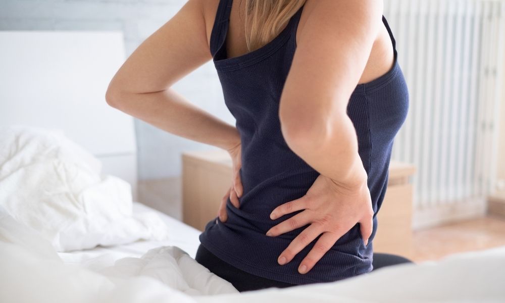 Female waking up in the morning with lower back pain